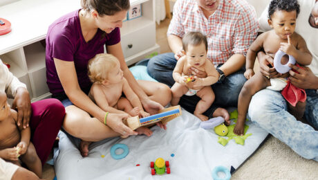 Kinder und Eltern in einer Krabbelgruppe mit Spielzeug