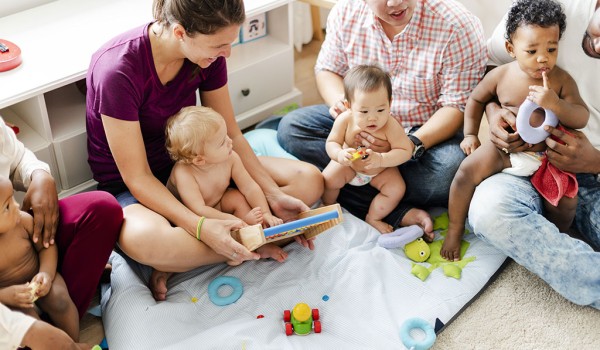 Kinder und Eltern in einer Krabbelgruppe mit Spielzeug