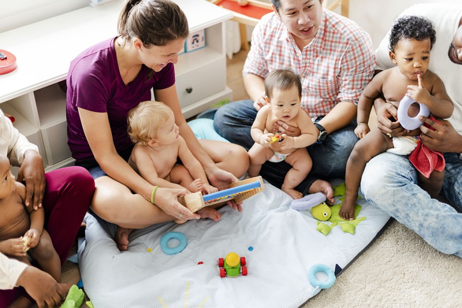 Kinder und Eltern in einer Krabbelgruppe mit Spielzeug