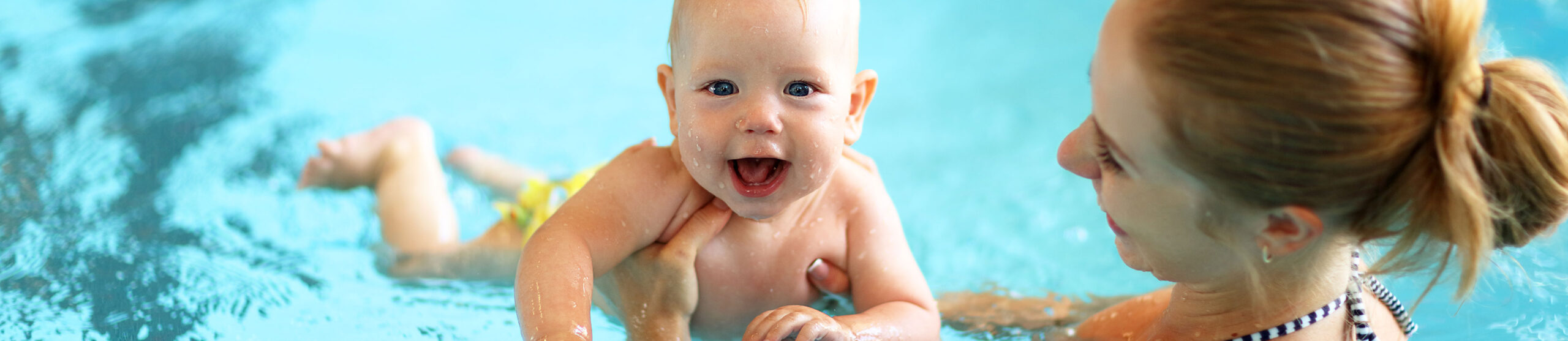 Titelbild - Mutter planscht mit Baby im Wasser.