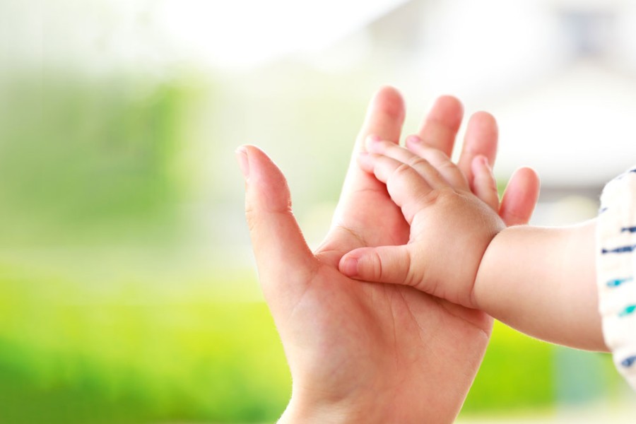 Mutter hält Babys Hand