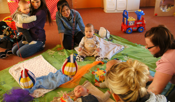 Eltern und ihre Babys haben Spaß in der Krabbelgruppe