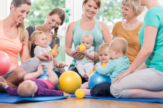 Fünf Mütter mit Ihren kleinen Kindern haben Spaß und spielen mit Ihren kleinen Babys und Kindern