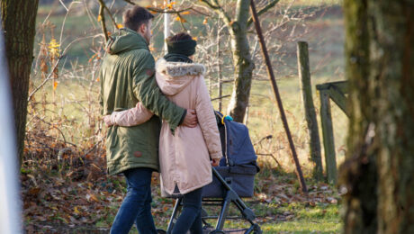 Paar mit Kinderwagen beim Spazierengehen