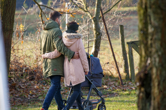 Paar mit Kinderwagen beim Spazierengehen